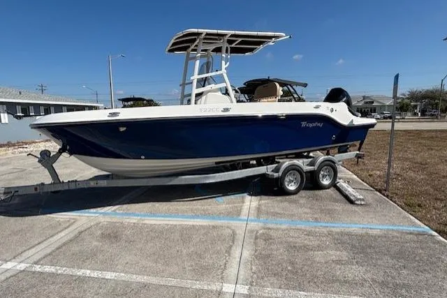 The Image of 2026 Bayliner Trophy T22CC boat on trailer in parking lot, side view. - 0