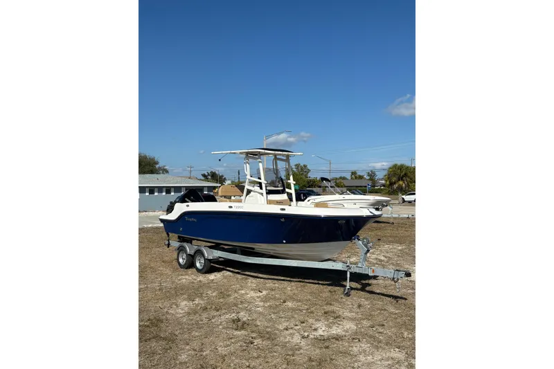 Slide: The Image of 2026 Bayliner Trophy T22CC boat on trailer under clear blue sky. - 10