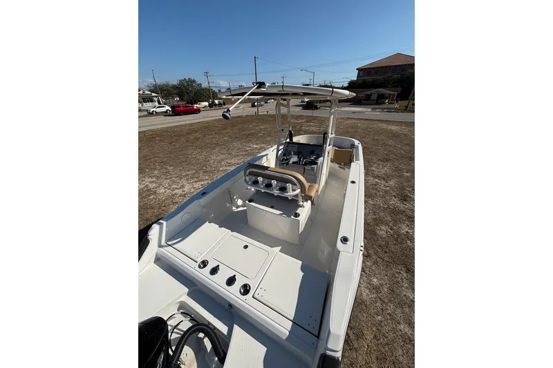 Slide: The Image of 2026 Bayliner Trophy T22CC boat with center console and seating, parked on dry land. - 14