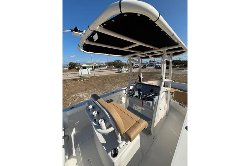 Slide: The Image of 2026 Bayliner Trophy T22CC boat interior with steering console and seating under a canopy. - 17