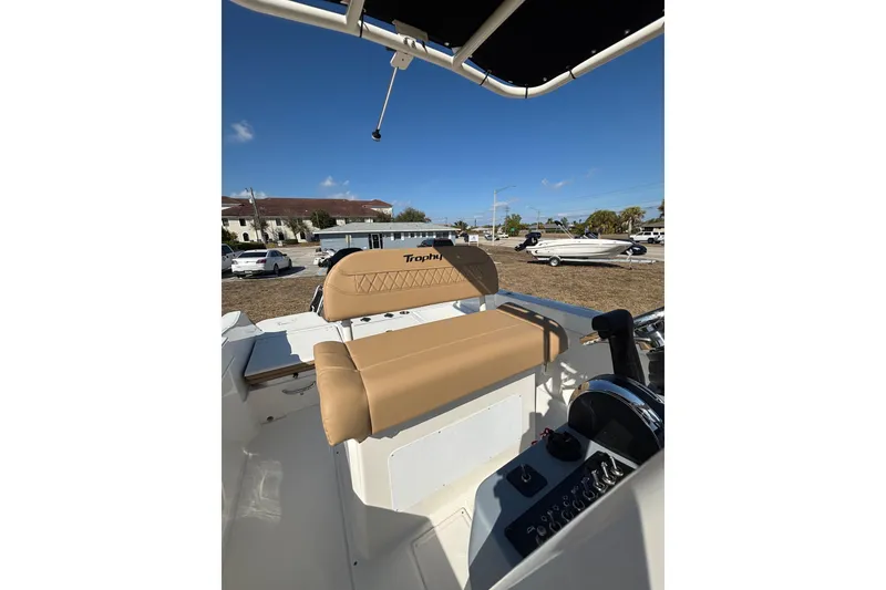 Slide: The Image of 2026 Bayliner Trophy T22CC boat interior with tan seating and control panel. - 25