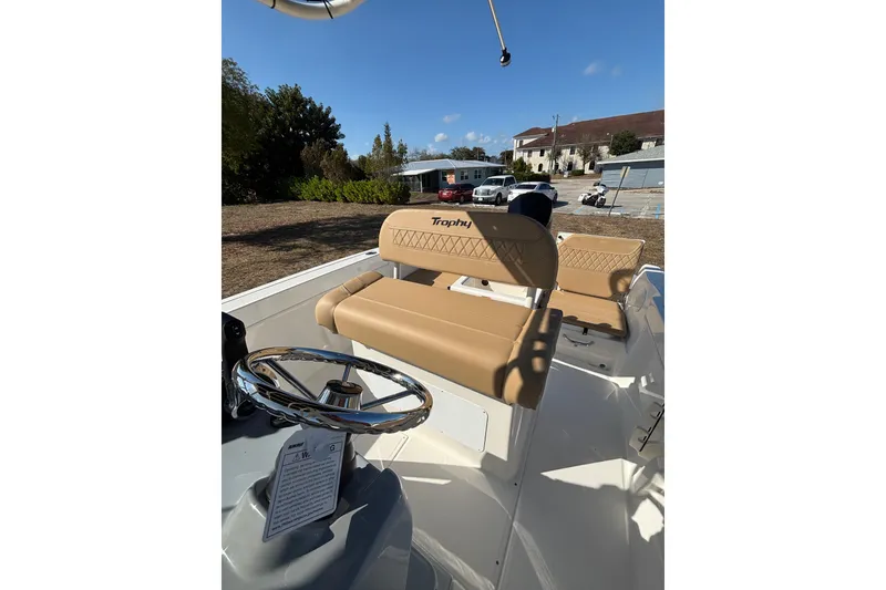 Slide: The Image of 2026 Bayliner Trophy T22CC boat interior with tan seating and steering wheel. - 29