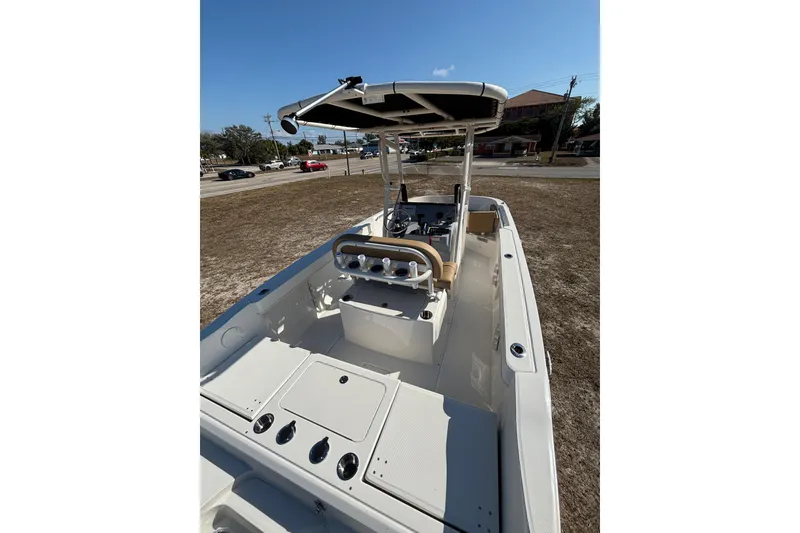 Slide: The Image of 2026 Bayliner Trophy T22CC boat interior with console and seating, parked on land. - 31