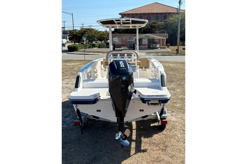 Slide: The Image of 2026 Bayliner Trophy T22CC boat with outboard motor, parked on grass. - 7