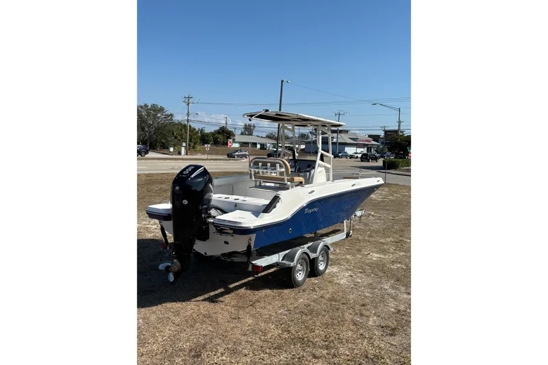 Slide: The Image of 2026 Bayliner Trophy T22CC boat on trailer, parked outdoors under clear sky. - 8