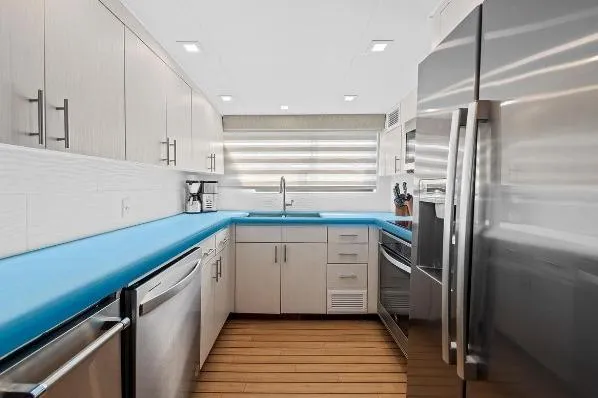 Slide: The Image of Modern kitchen interior on 1989 Hatteras 70 Motor Yacht with blue countertops and stainless steel appliances. - 10