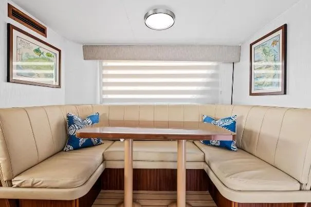 Slide: The Image of Elegant dining area in 1989 Hatteras 70 Motor Yacht with beige seating and nautical decor. - 11