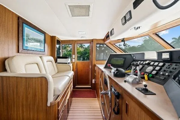 Slide: The Image of 1989 Hatteras 70 Motor Yacht helm with wood paneling and modern controls. - 12