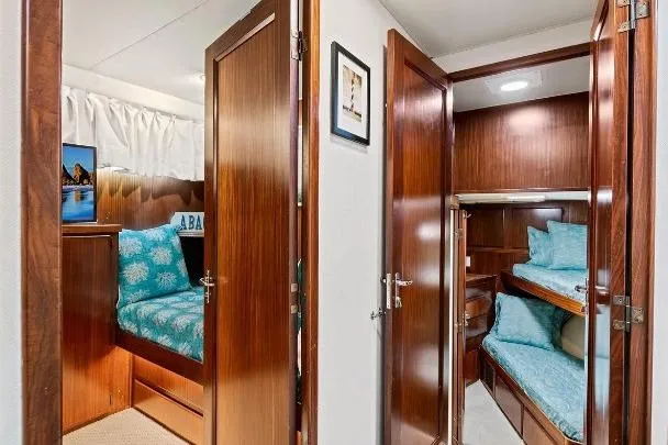 Slide: The Image of 1989 Hatteras 70 Motor Yacht interior with cozy twin cabins and wooden finishes. - 22