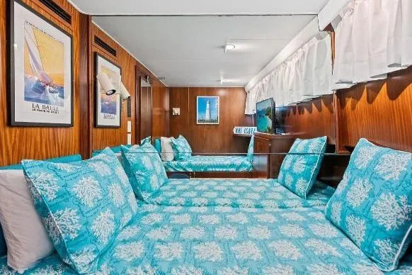 Slide: The Image of Cozy cabin interior of 1989 Hatteras 70 Motor Yacht with turquoise bedding and nautical decor. - 24