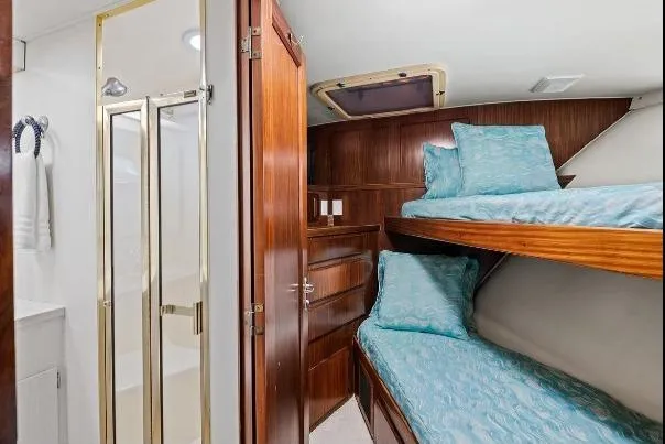 Slide: The Image of 1989 Hatteras 70 Motor Yacht cabin with bunk beds and ensuite bathroom. - 27
