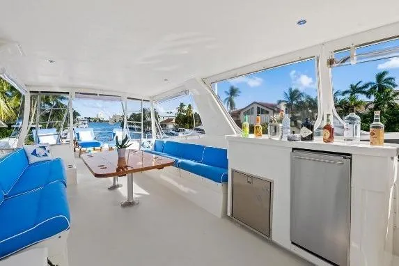 Slide: The Image of Luxurious 1989 Hatteras 70 Motor Yacht interior with blue seating and bar area. - 28