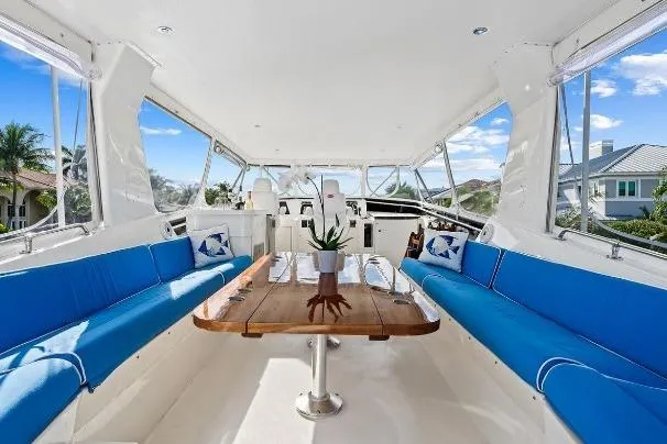 Slide: The Image of 1989 Hatteras 70 Motor Yacht interior with blue seating and wooden table. - 29