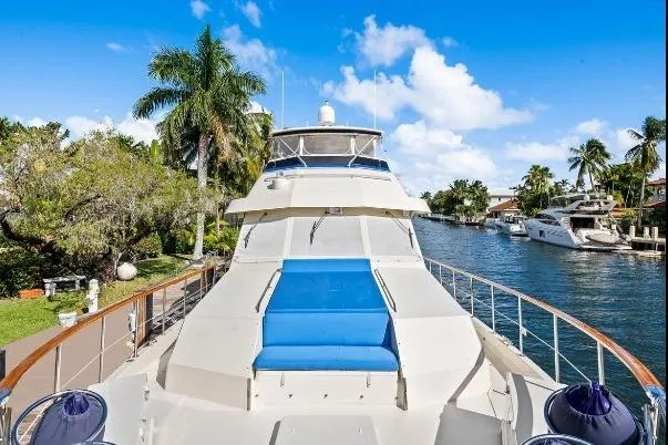 Slide: The Image of 1989 Hatteras 70 Motor Yacht docked by a scenic canal with palm trees. - 31