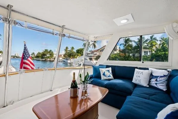 Slide: The Image of Luxurious 1989 Hatteras 70 Motor Yacht interior with blue seating and waterfront view. - 7