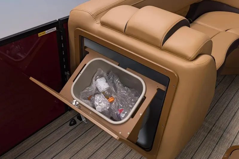 Slide: The Image of Built-in trash compartment in 2026 SunCatcher Fusion 324SS boat, featuring tan leather seating. - 13