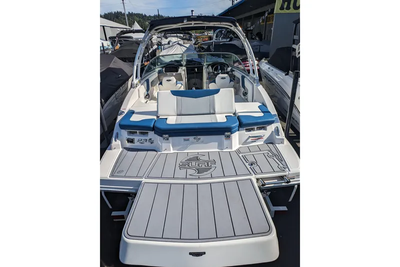 Slide: The Image of 2023 Chaparral 23 Surf boat with blue and white seating, rear view. - 14