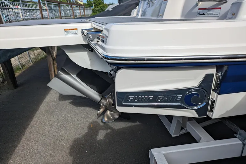 Slide: The Image of 2023 Chaparral 23 Surf boat with Surf Gate feature, docked on a trailer. - 16