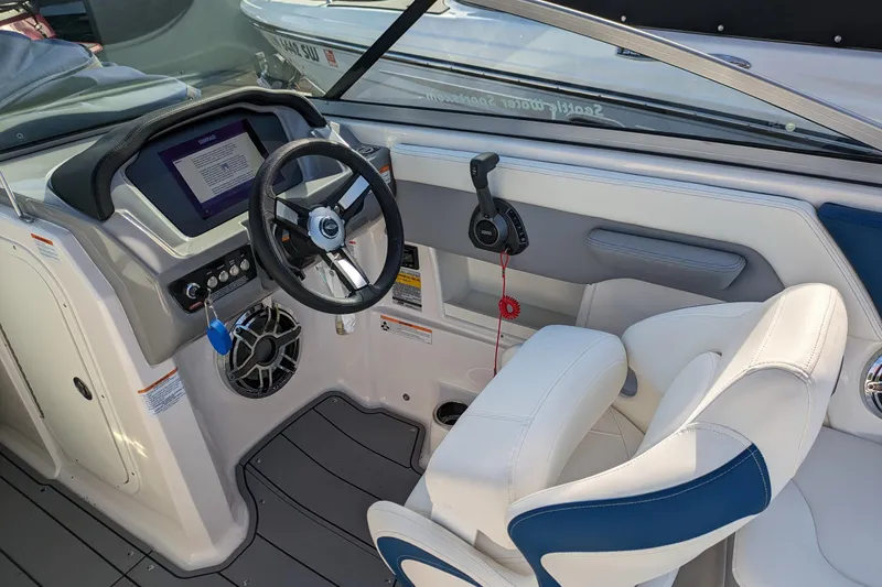 Slide: The Image of 2023 Chaparral 23 Surf boat interior with steering wheel and control panel. - 2
