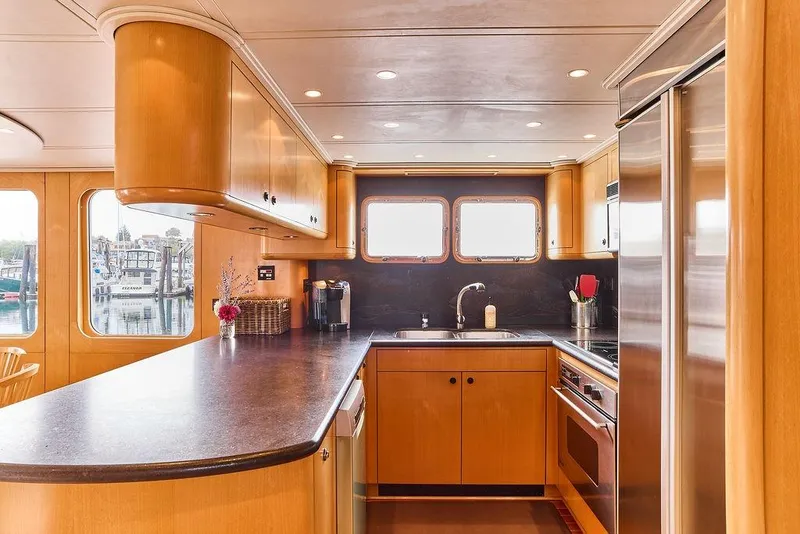 Slide: The Image of Luxurious kitchen interior of 2000 Northern Marine 75 yacht with modern appliances and wood cabinetry. - 28