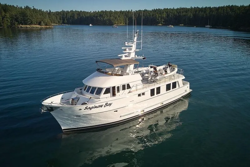 Slide: The Image of Luxury Northern Marine 75 yacht from 2000 on serene water, surrounded by lush forest. - 72