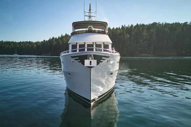 Slide: The Image of Front view of a 2000 Northern Marine 75 yacht on calm water, surrounded by trees. - 73