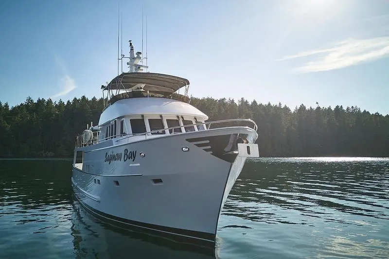 Slide: The Image of Luxury Northern Marine 75 yacht from 2000 on serene water with forest backdrop. - 74
