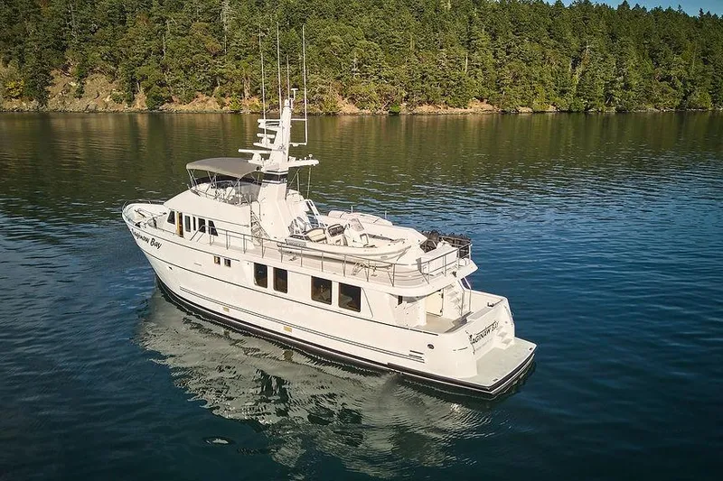 Slide: The Image of Luxury Northern Marine 75 yacht from 2000 on serene water, surrounded by lush forest. - 83