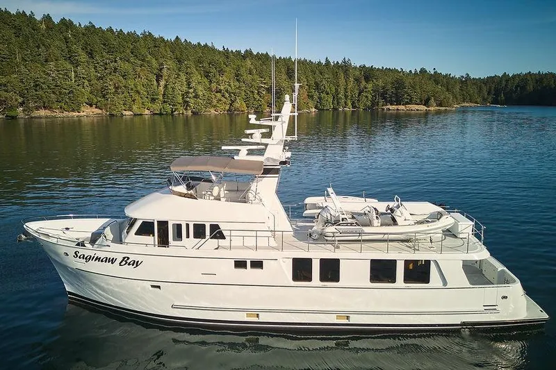 Slide: The Image of Luxury Northern Marine 75 yacht from 2000 on serene water, surrounded by lush forest. - 84