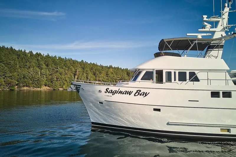 Slide: The Image of Northern Marine 75 yacht "Saginaw Bay" cruising near forested shoreline, 2000 model. - 85