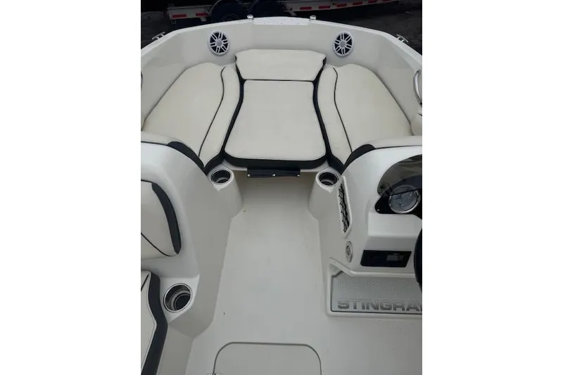 Slide: The Image of 2023 Stingray 182 SC boat interior with cushioned seating and cup holders. - 11