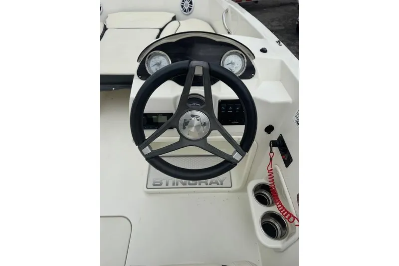 Slide: The Image of 2023 Stingray 182 SC boat dashboard with steering wheel and gauges. - 12