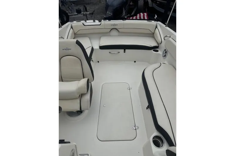 Slide: The Image of 2023 Stingray 182 SC boat interior with white seating and storage compartments. - 13