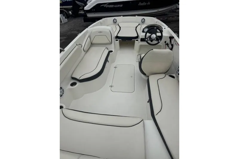 Slide: The Image of 2023 Stingray 182 SC boat interior with white seating and steering wheel. - 14