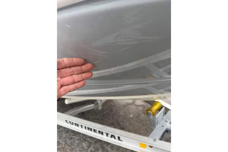 Slide: The Image of Hand inspecting 2023 Stingray 182 SC boat hull on trailer. - 17