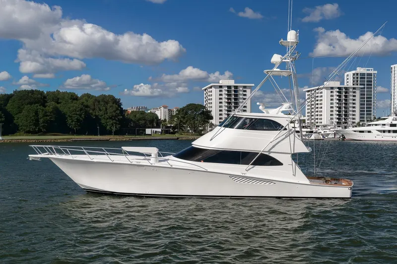 Slide: The Image of 2012 Viking 70 Enclosed Bridge yacht cruising near modern waterfront buildings. - 107