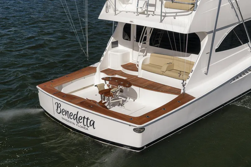 Slide: The Image of 2012 Viking 70 Enclosed Bridge yacht, rear view, on water, featuring teak deck and seating. - 11