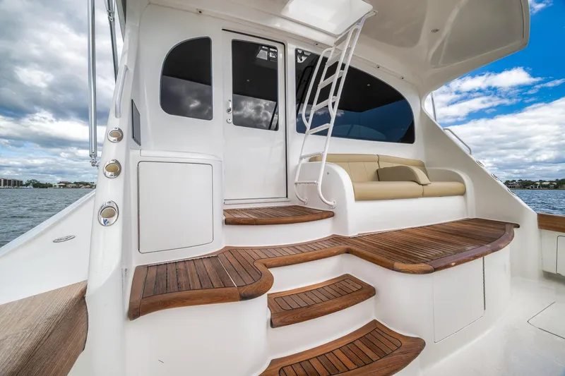 Slide: The Image of Luxurious 2012 Viking 70 Enclosed Bridge yacht with elegant wooden steps and seating area. - 21