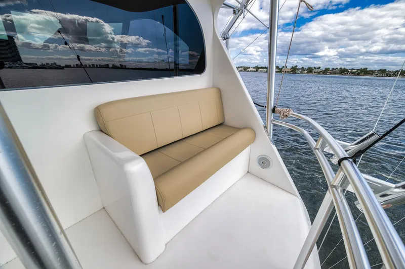 Slide: The Image of 2012 Viking 70 Enclosed Bridge yacht with tan seating, overlooking serene waters. - 22