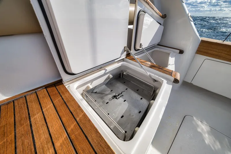 Slide: The Image of Open storage compartment on 2012 Viking 70 Enclosed Bridge yacht with wooden deck. - 24