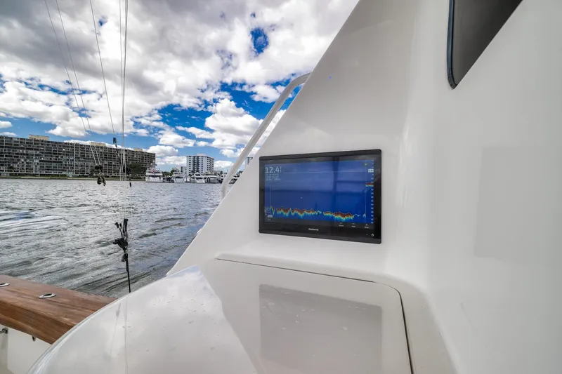 Slide: The Image of 2012 Viking 70 Enclosed Bridge yacht with navigation display, docked by waterfront buildings. - 35