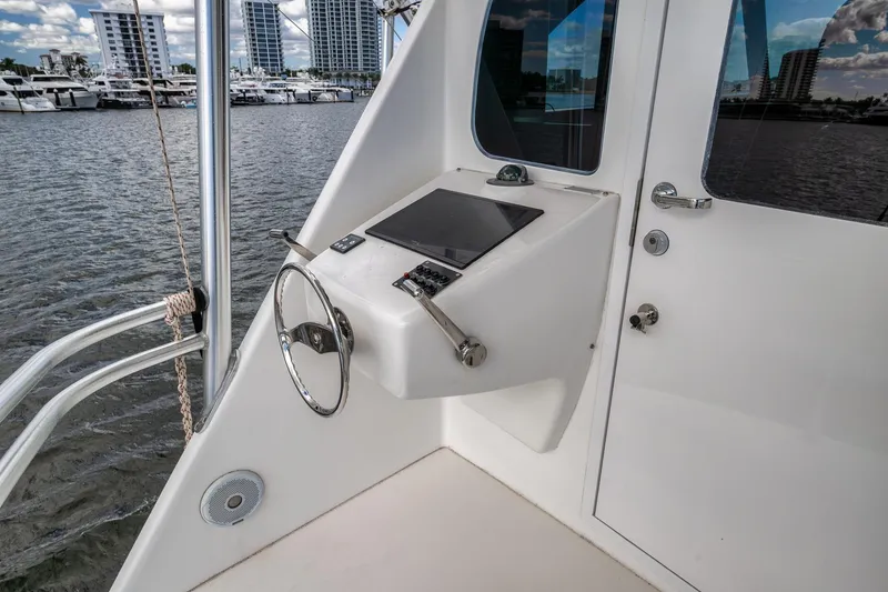 Slide: The Image of 2012 Viking 70 Enclosed Bridge yacht helm with steering wheel and control panel. - 42