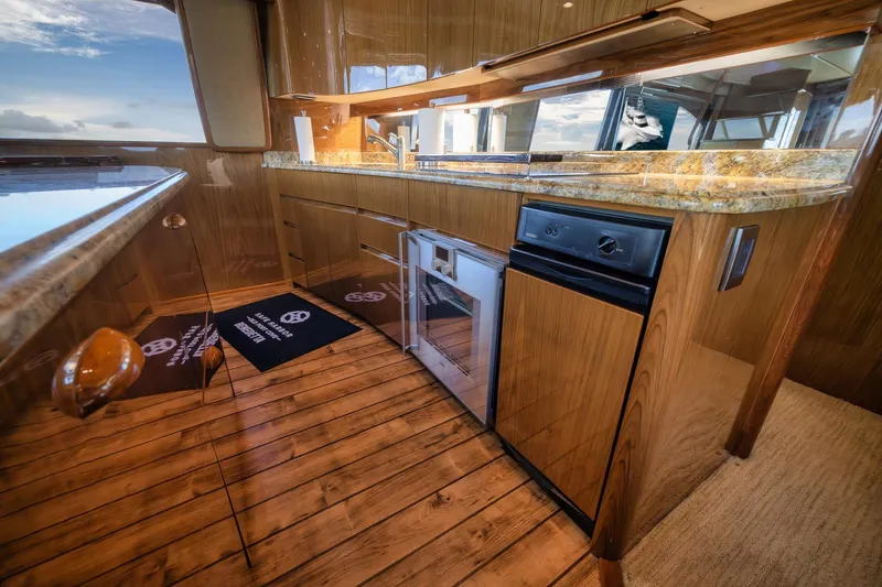 Slide: The Image of Luxurious kitchen interior of 2012 Viking 70 Enclosed Bridge yacht with wooden flooring. - 55