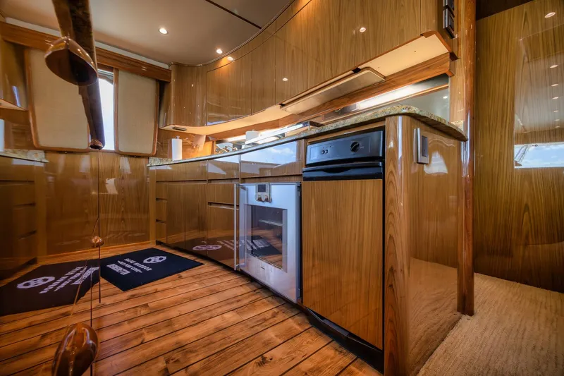 Slide: The Image of Luxurious kitchen interior of 2012 Viking 70 Enclosed Bridge yacht with wood finish. - 56