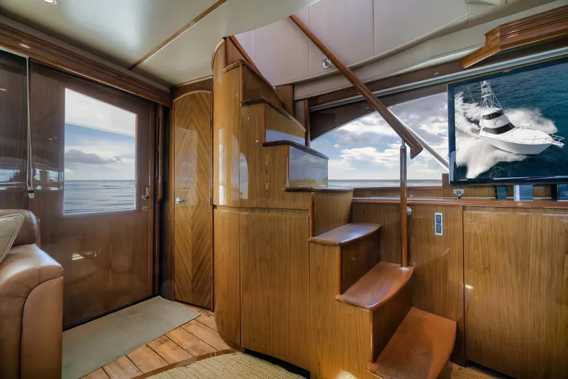 Slide: The Image of Luxurious interior of 2012 Viking 70 Enclosed Bridge yacht with wooden staircase and ocean view. - 58