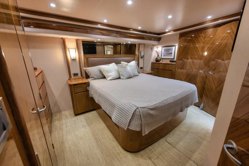 Slide: The Image of Luxurious bedroom interior of 2012 Viking 70 Enclosed Bridge yacht, featuring elegant wood finishes. - 72