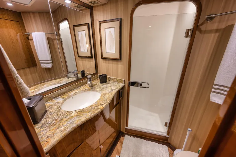Slide: The Image of Luxurious bathroom in 2012 Viking 70 Enclosed Bridge yacht with granite countertop and glass shower. - 76