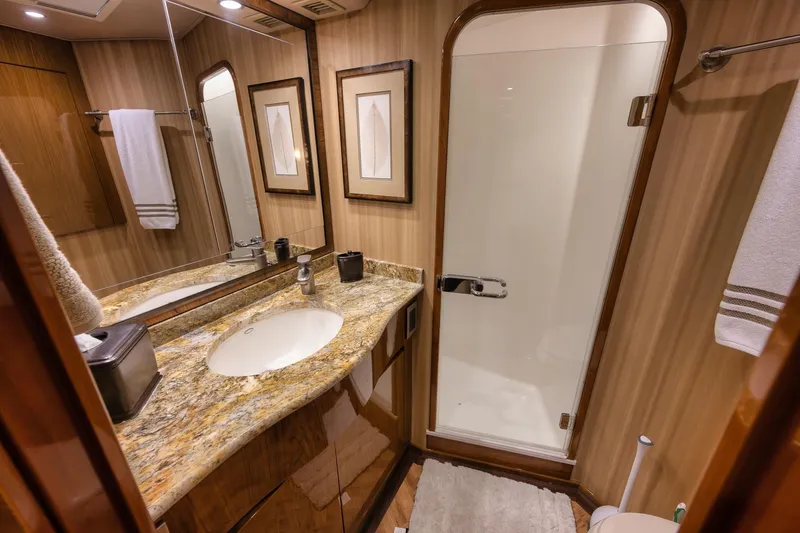 Slide: The Image of Luxurious bathroom in 2012 Viking 70 Enclosed Bridge yacht with granite countertop and glass shower. - 77
