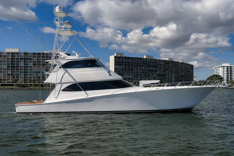 Slide: The Image of 2012 Viking 70 Enclosed Bridge yacht cruising near modern waterfront buildings. - 8