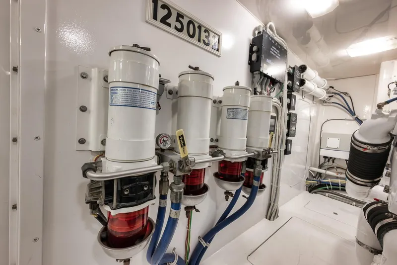 Slide: The Image of Engine room of 2012 Viking 70 Enclosed Bridge yacht, featuring fuel filters and wiring. - 99